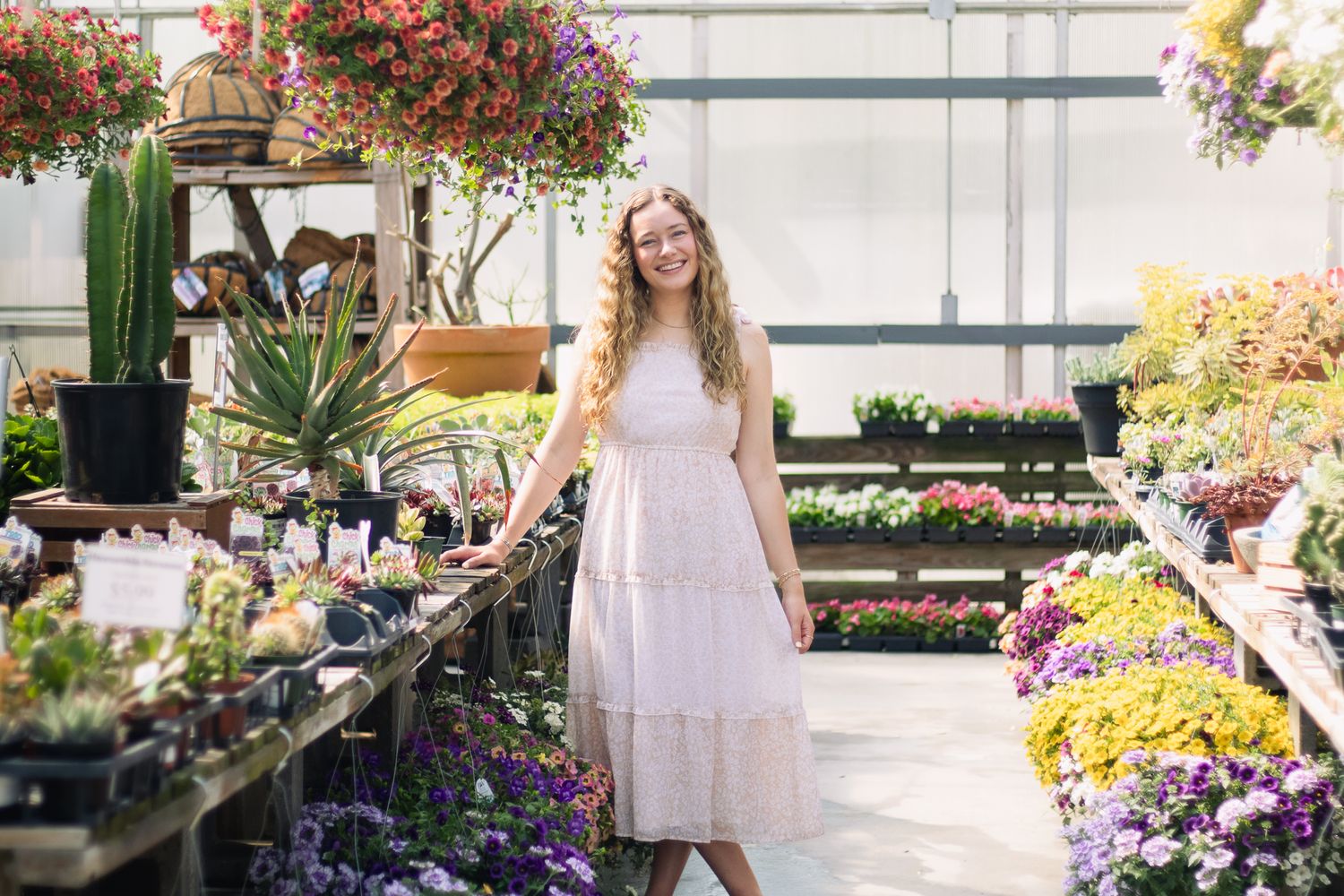 Blonde young adult posing for a South Carolina photographer in Florence, SC at a greenhouse photoshoot portraits. Candid and true-to-color