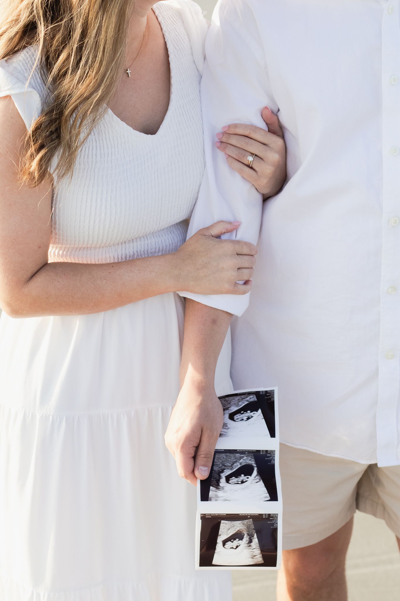 Couple posing for a South Carolina photographer in Huntington Beach State Park on the beach for pregnancy announcement photos portraits.