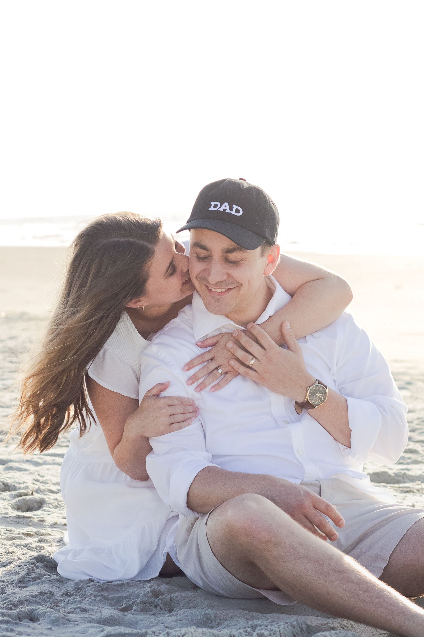 Couple posing for a South Carolina photographer in Huntington Beach State Park on the beach for pregnancy announcement photos portraits.