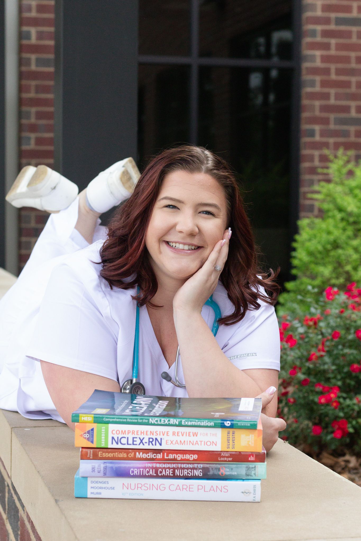Nursing college graduate portraits posing for a South Carolina photographer in Florence, SC for their senior pictures. stethoscope textbooks