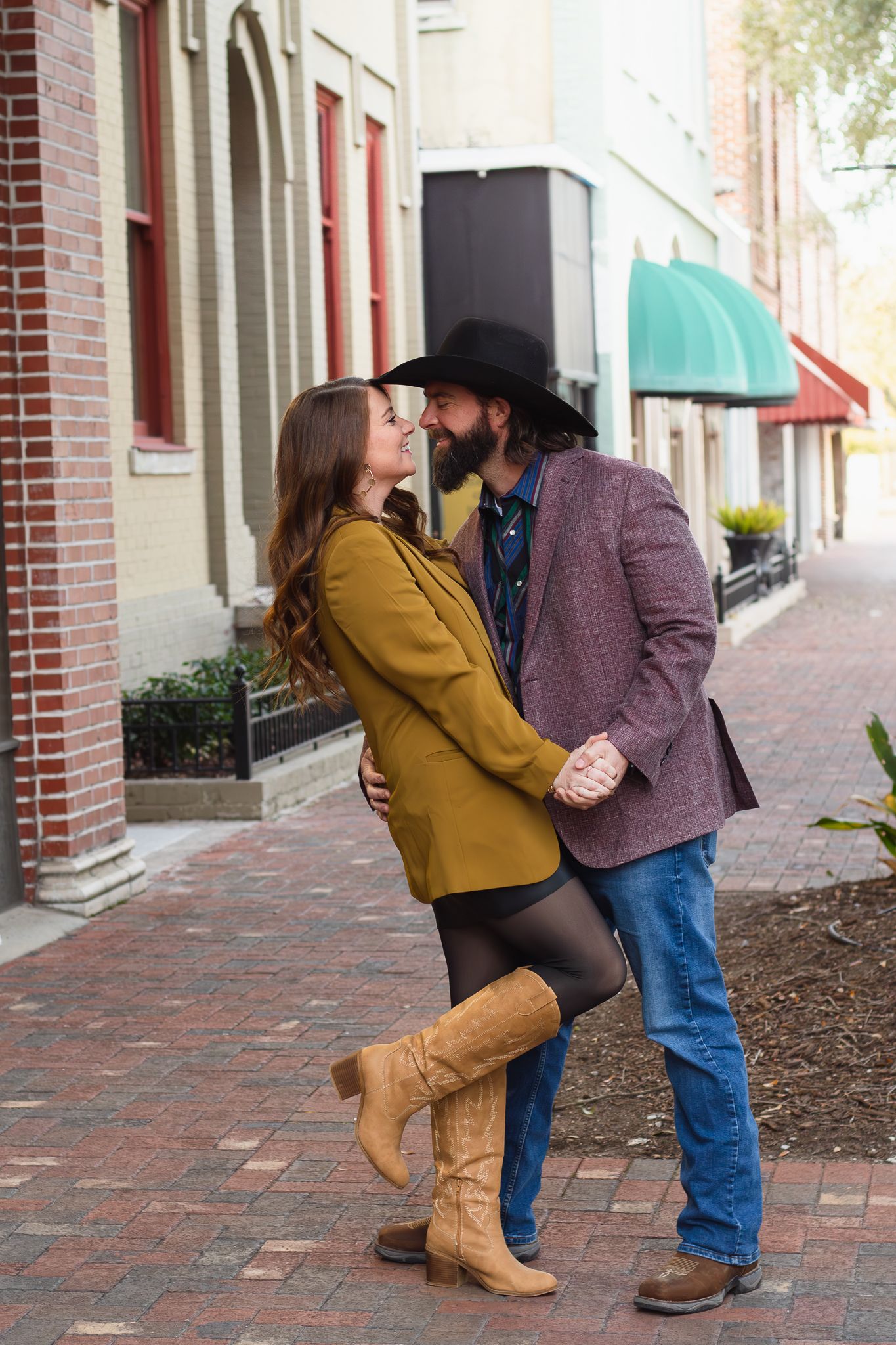 Couple posing for South Carolina photographer at downtown Sumter engagement portraits photoshoot. Candid true to color sc country