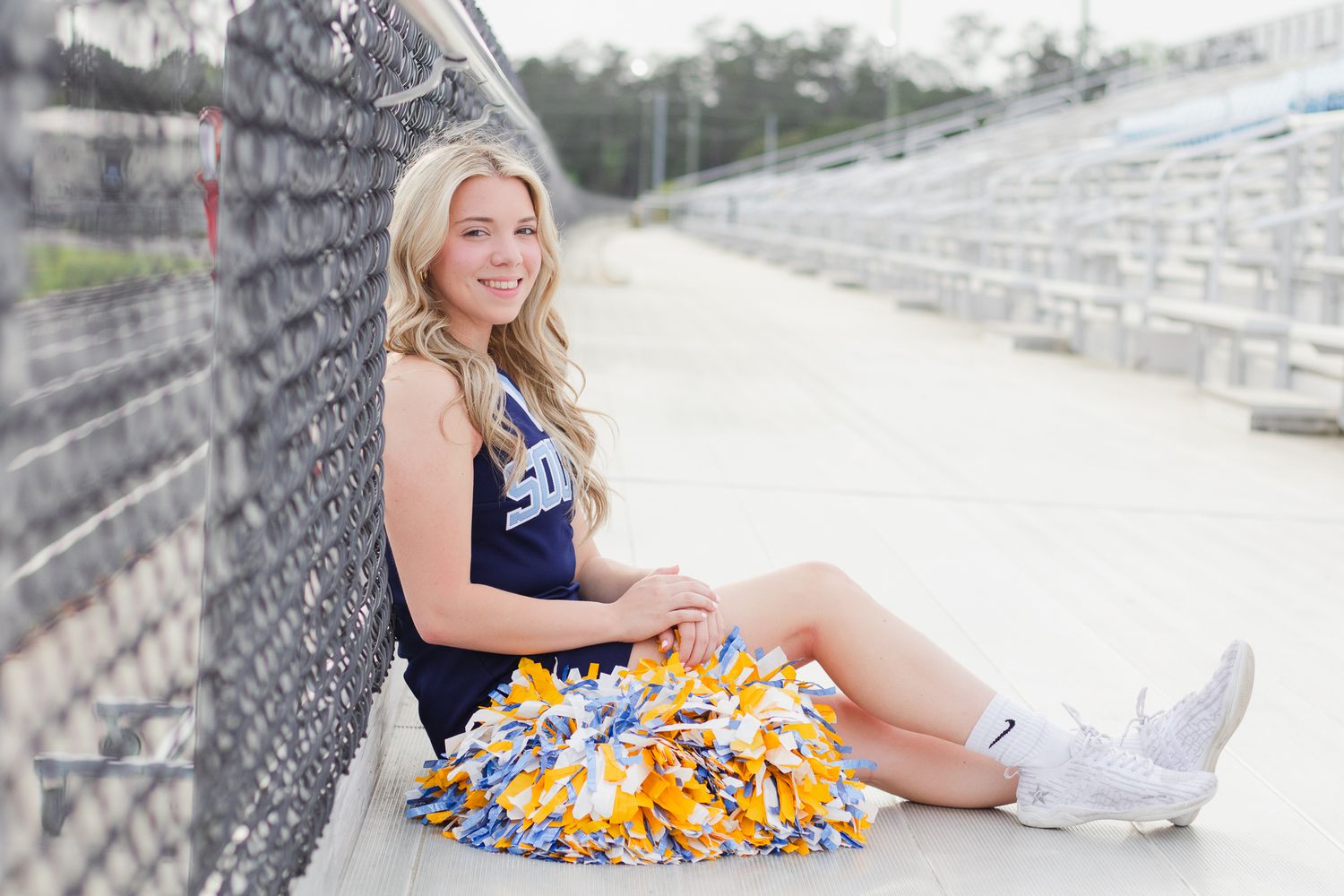 High school senior cheerleader posing for South Carolina photographer in Florence, SC for their senior pictures graduation portraits. Candid