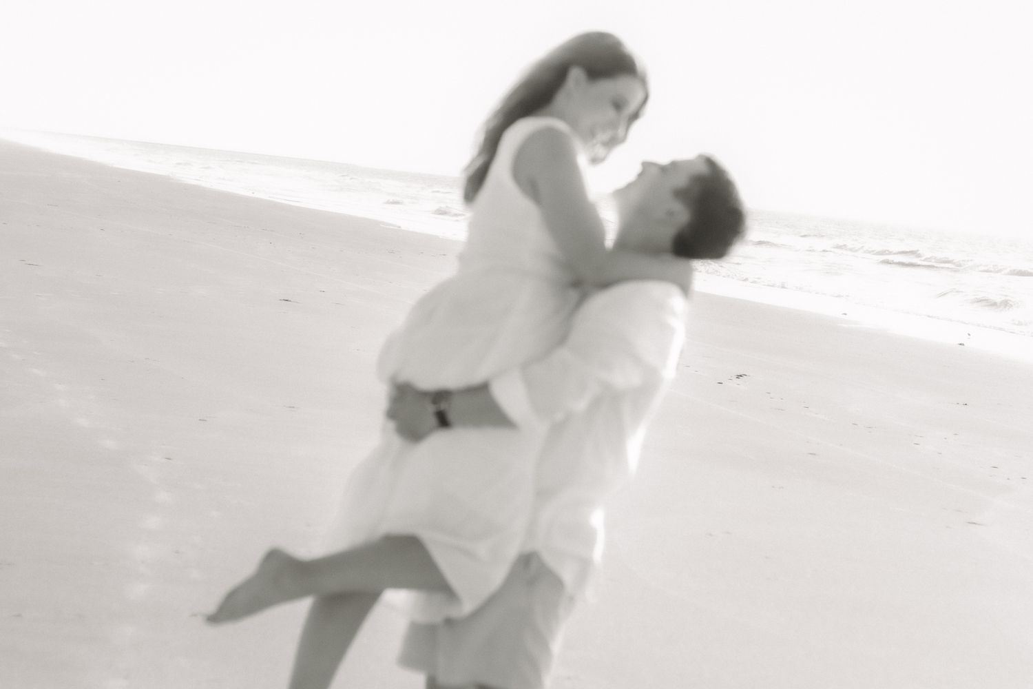 Couple posing for a South Carolina photographer in Huntington Beach State Park on the beach for pregnancy announcement photos portraits.
