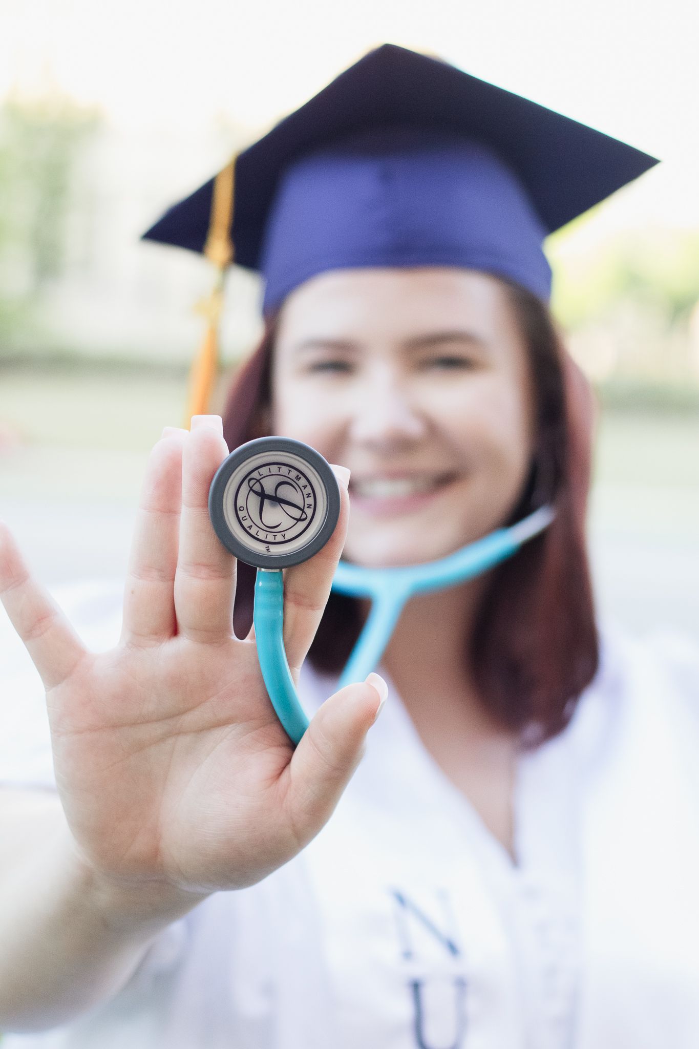Nursing college graduate portraits posing for a South Carolina photographer in Florence, SC for their senior pictures. stethoscope textbooks