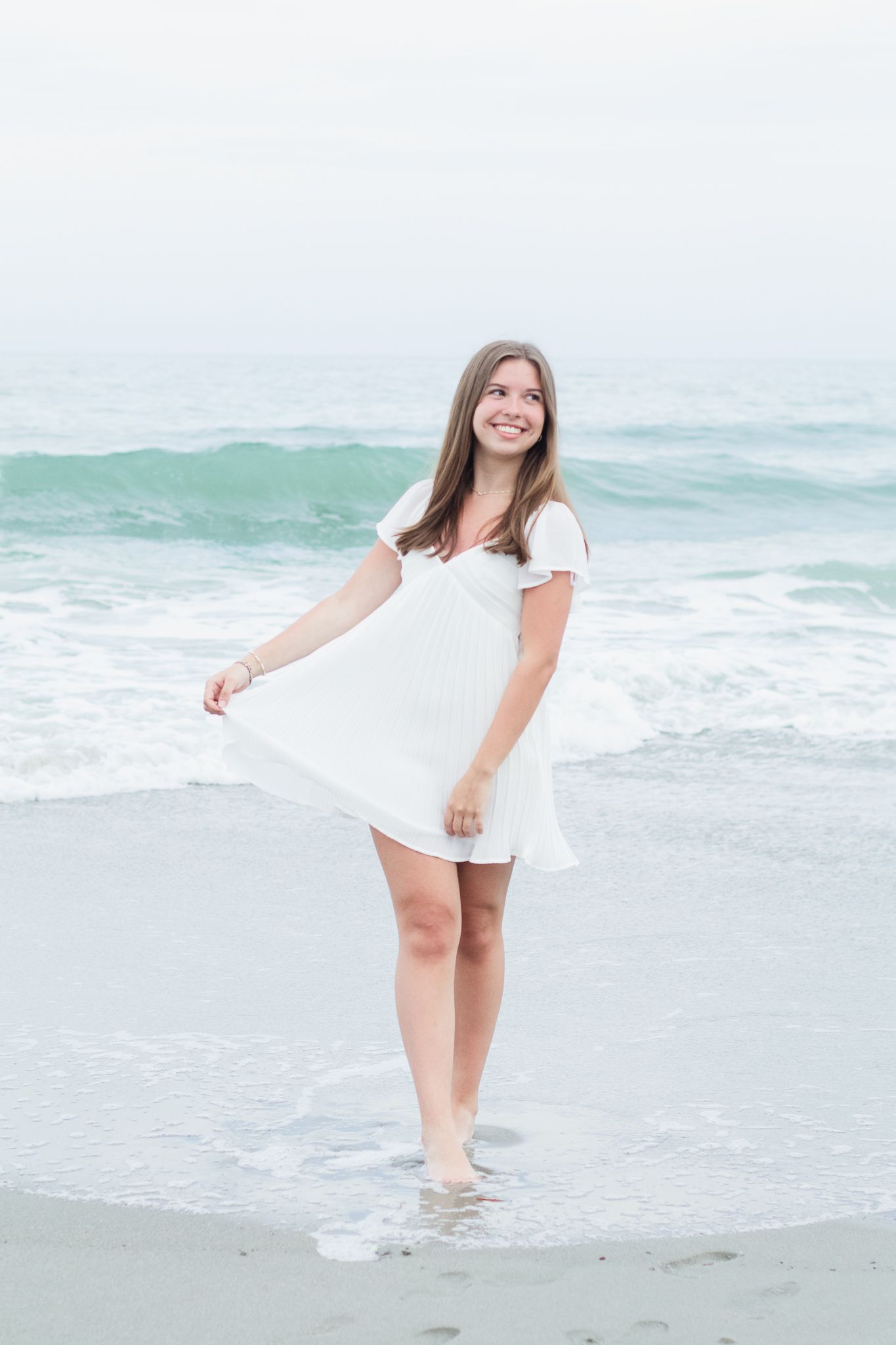 High school senior posing for a South Carolina photographer in Garden City Beach, SC for their senior pictures graduation portraits.