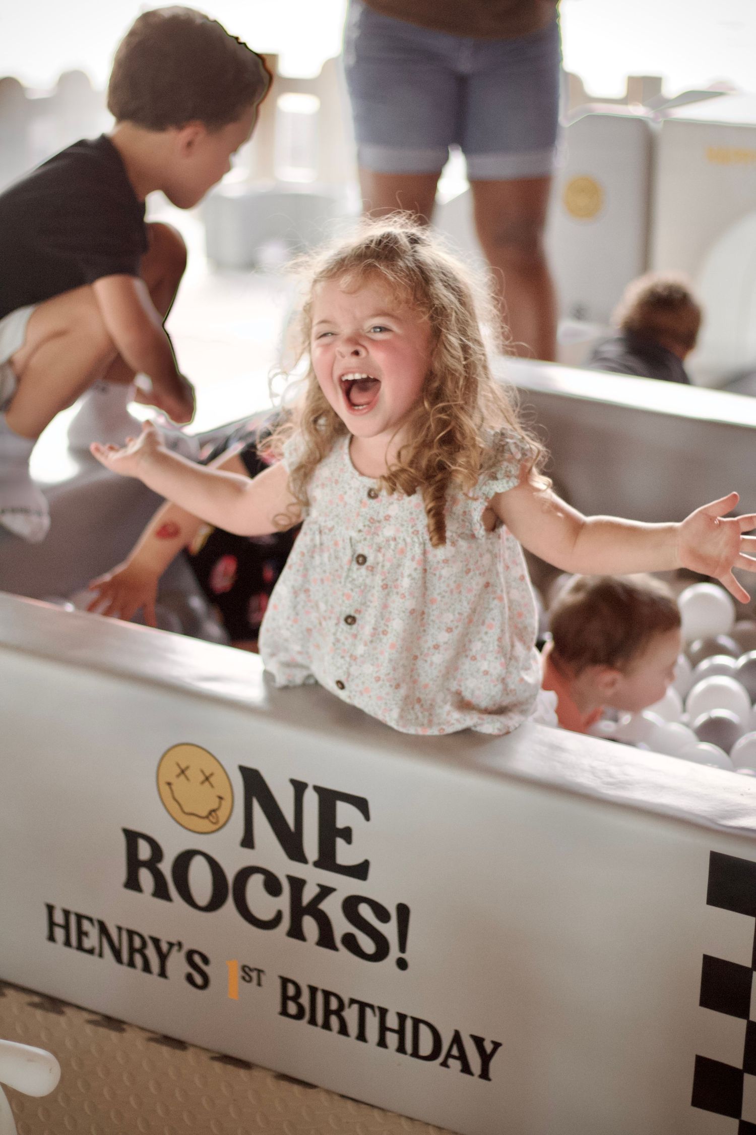 A child laughs joyfully at a birthday party with 'Rocks' text visible in the background.