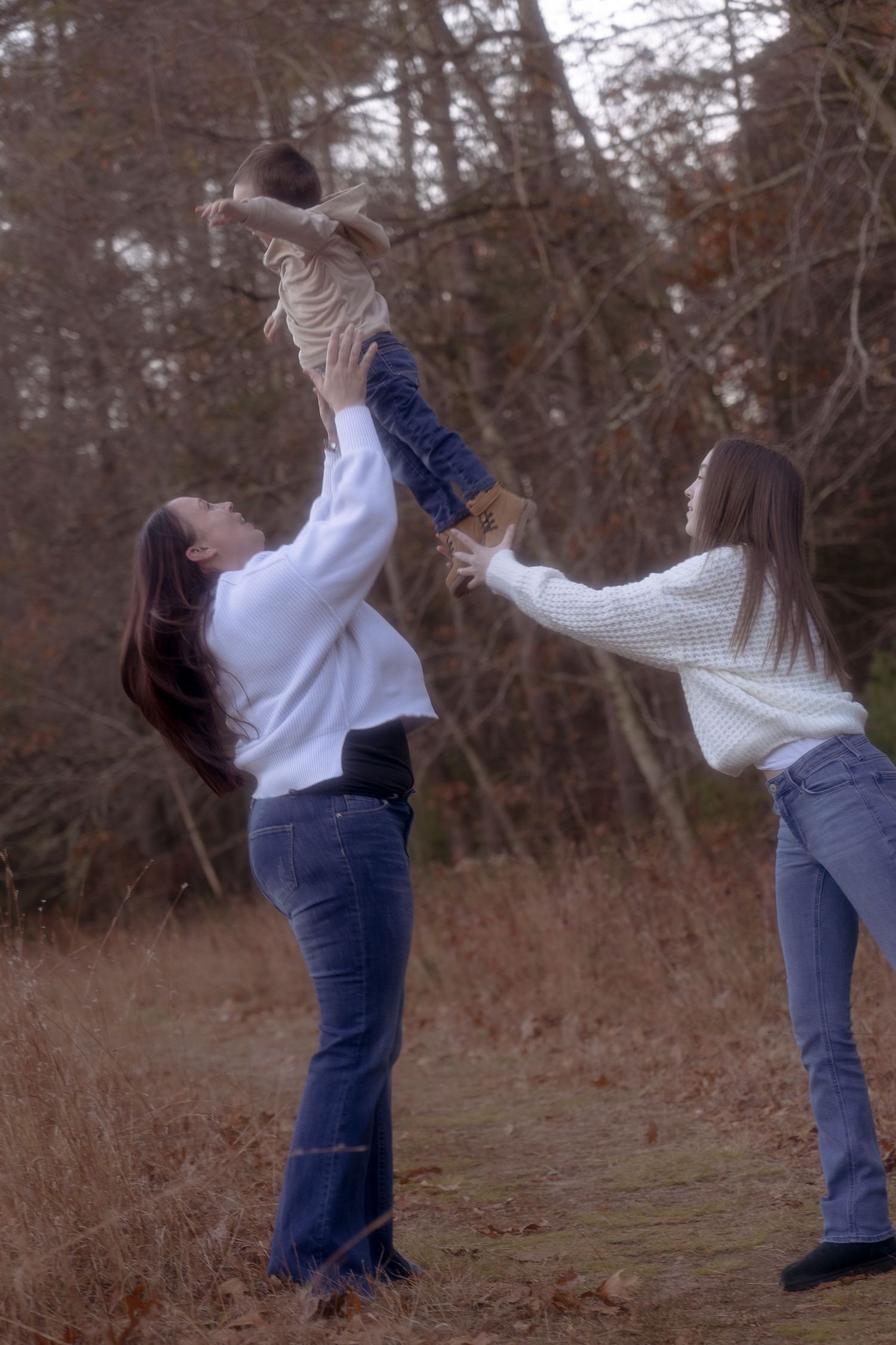 A couple in casual attire performs a romantic dance lift sequence outdoors against a backdrop of bare winter trees.