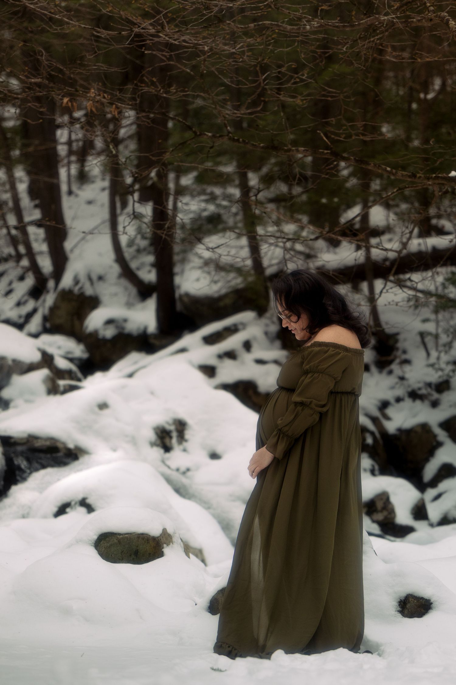 A person in a long cloak walks through a snowy winter forest landscape, creating a mystical atmosphere.