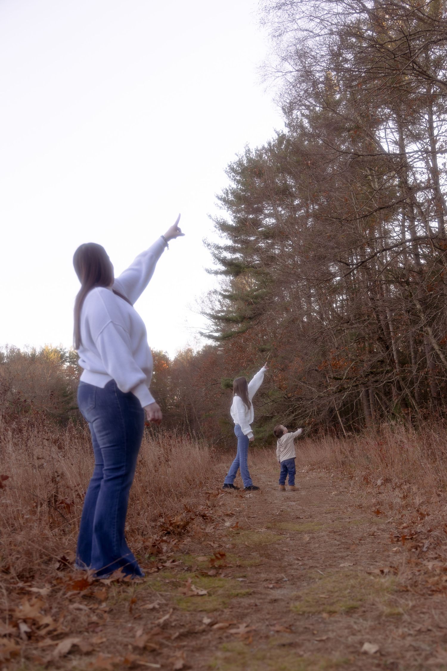 A sequence of figures in white shirts and jeans tumbling down a hill in an autumn forest setting.