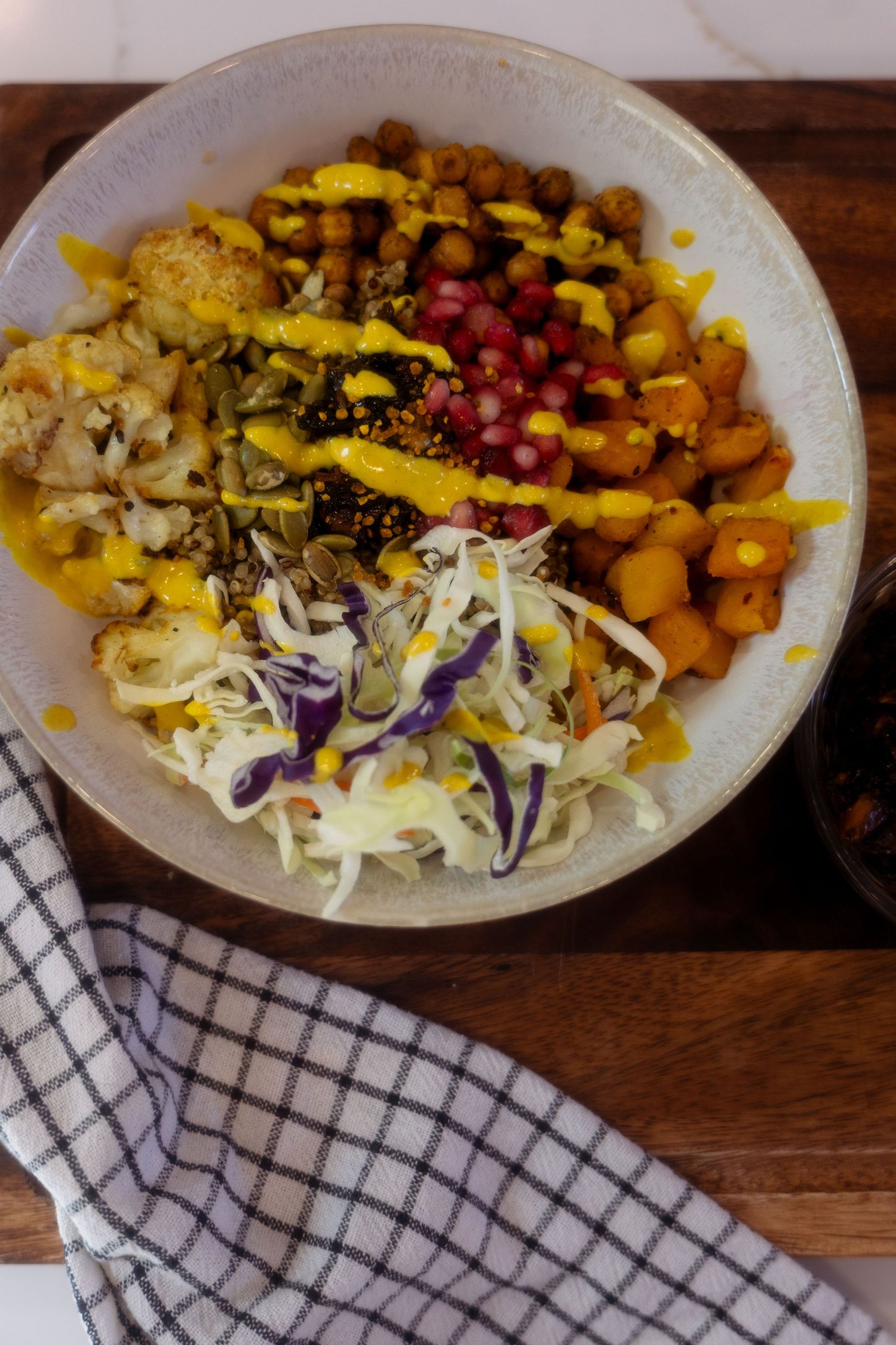 Plated meal showing progression of assembly with roasted butternut squash, fresh coleslaw, and bright red cranberries.
