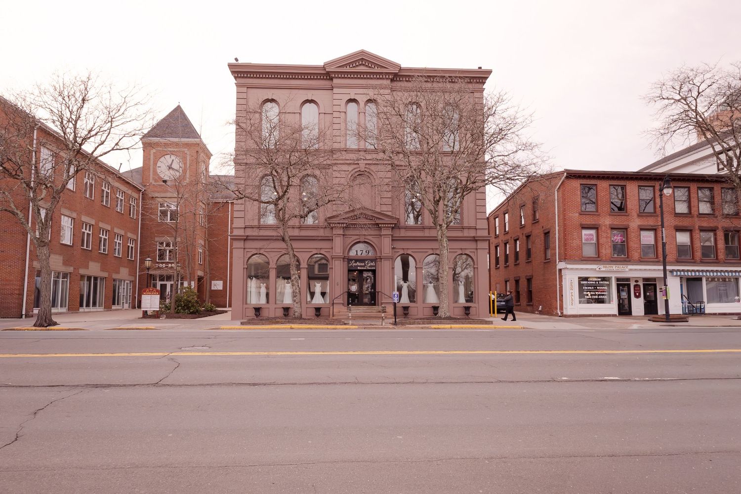 Historic downtown brick building with clock tower on a quiet street in a New England town.