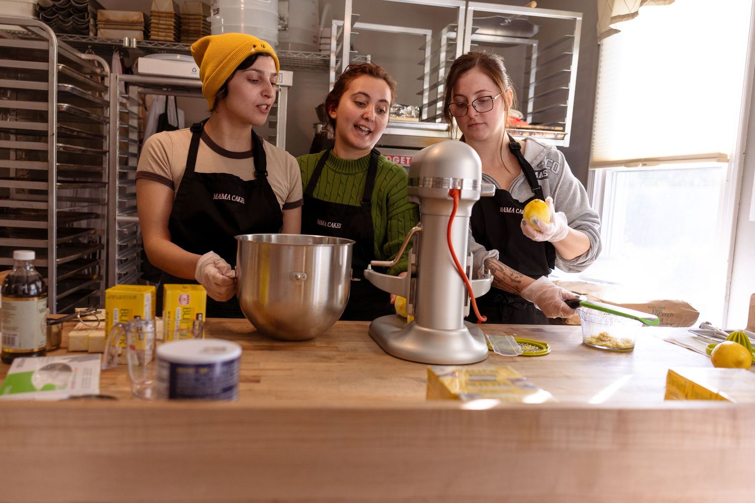 People gathered in a kitchen learning to cook and prepare food during a culinary class.