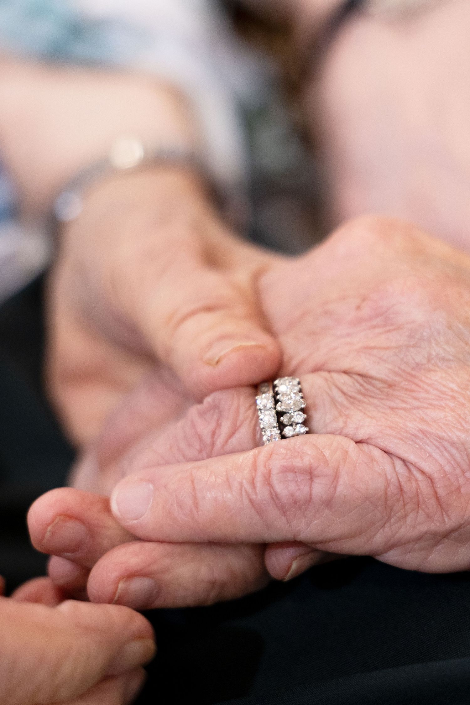 A series of close-up shots showing hands gently clasped together in a caring and supportive gesture.