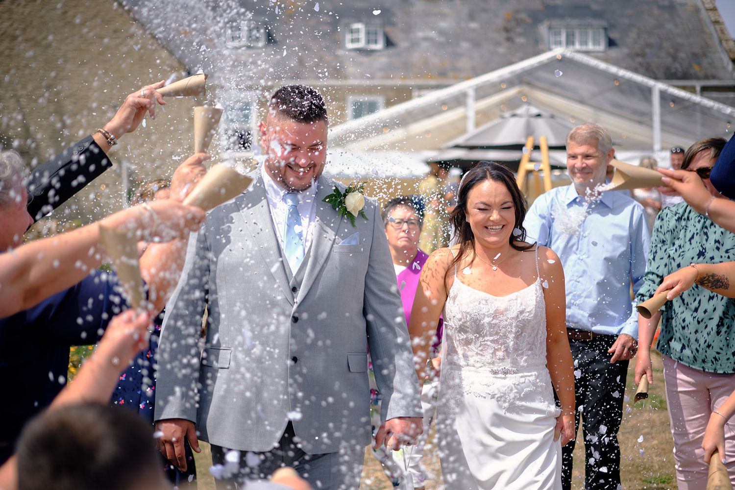 Wedding guests celebrate with champagne spraying during an outdoor reception party celebration.