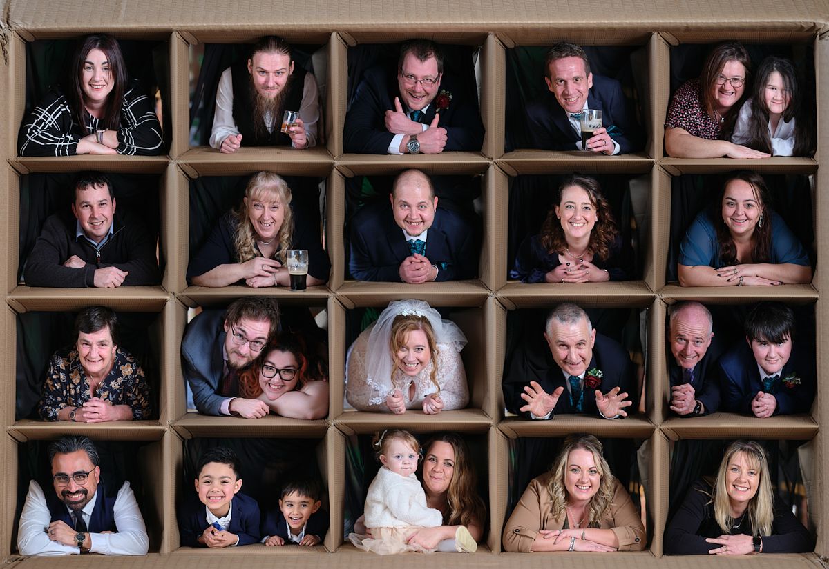 A creative photo collage of multiple portraits arranged in cardboard box compartments showing various expressions and poses.