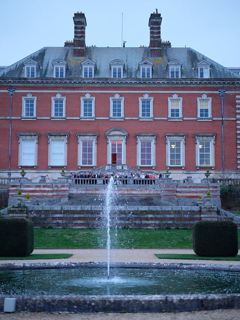 A series of ornate fountains in front of Bryanston School with classical architectural features and manicured gardens.