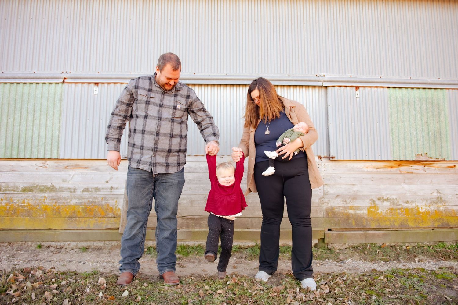 Family walking together outdoors against industrial background.