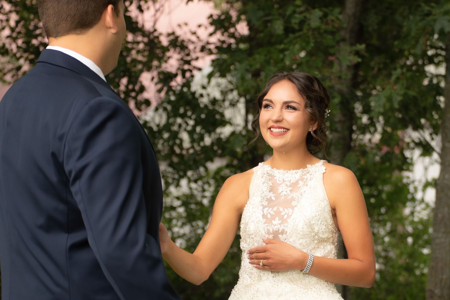 Candid moment between newlyweds sharing laughter during outdoor wedding ceremony.