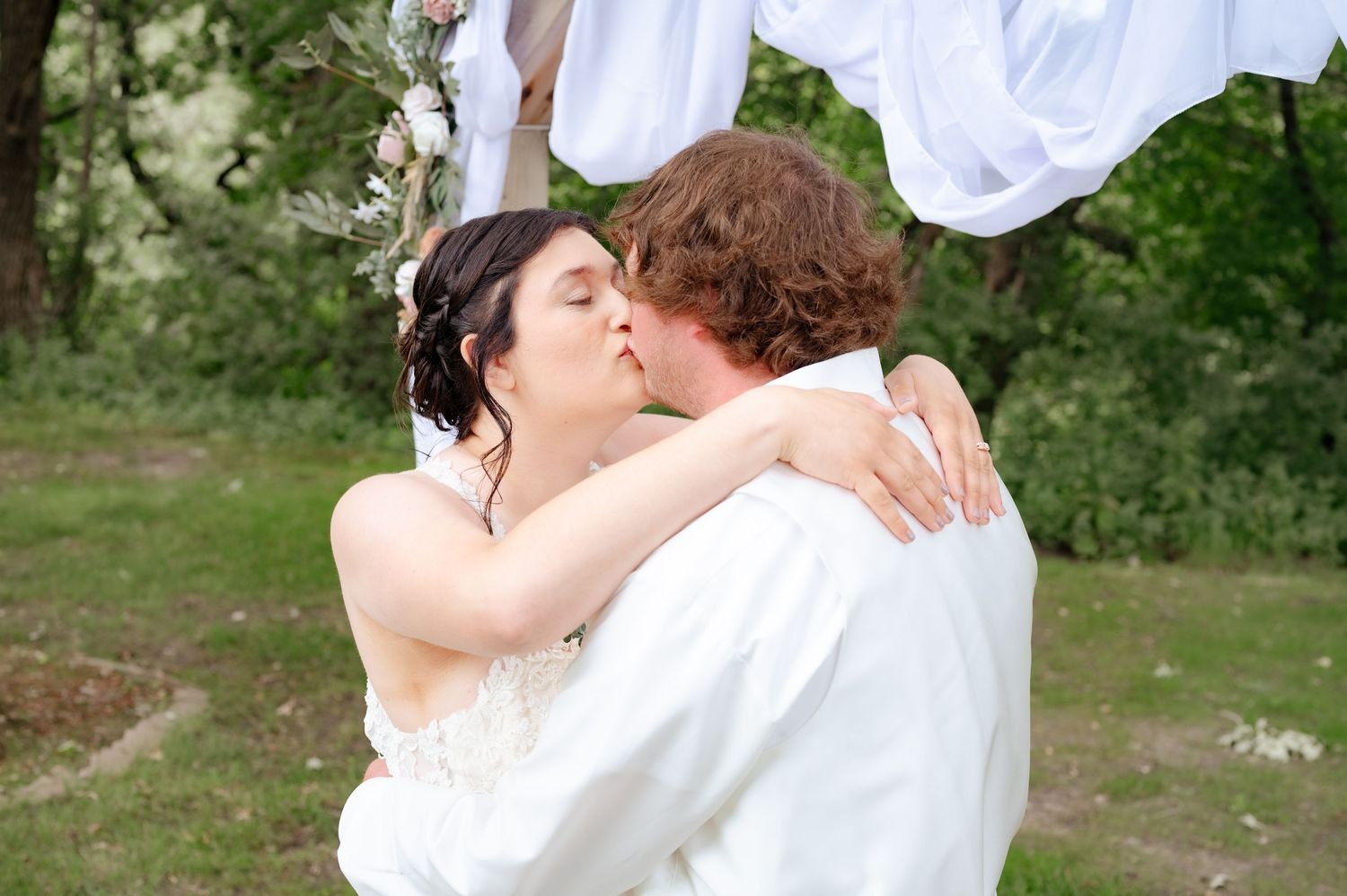 Couple sharing romantic moment outdoors during wedding photoshoot.