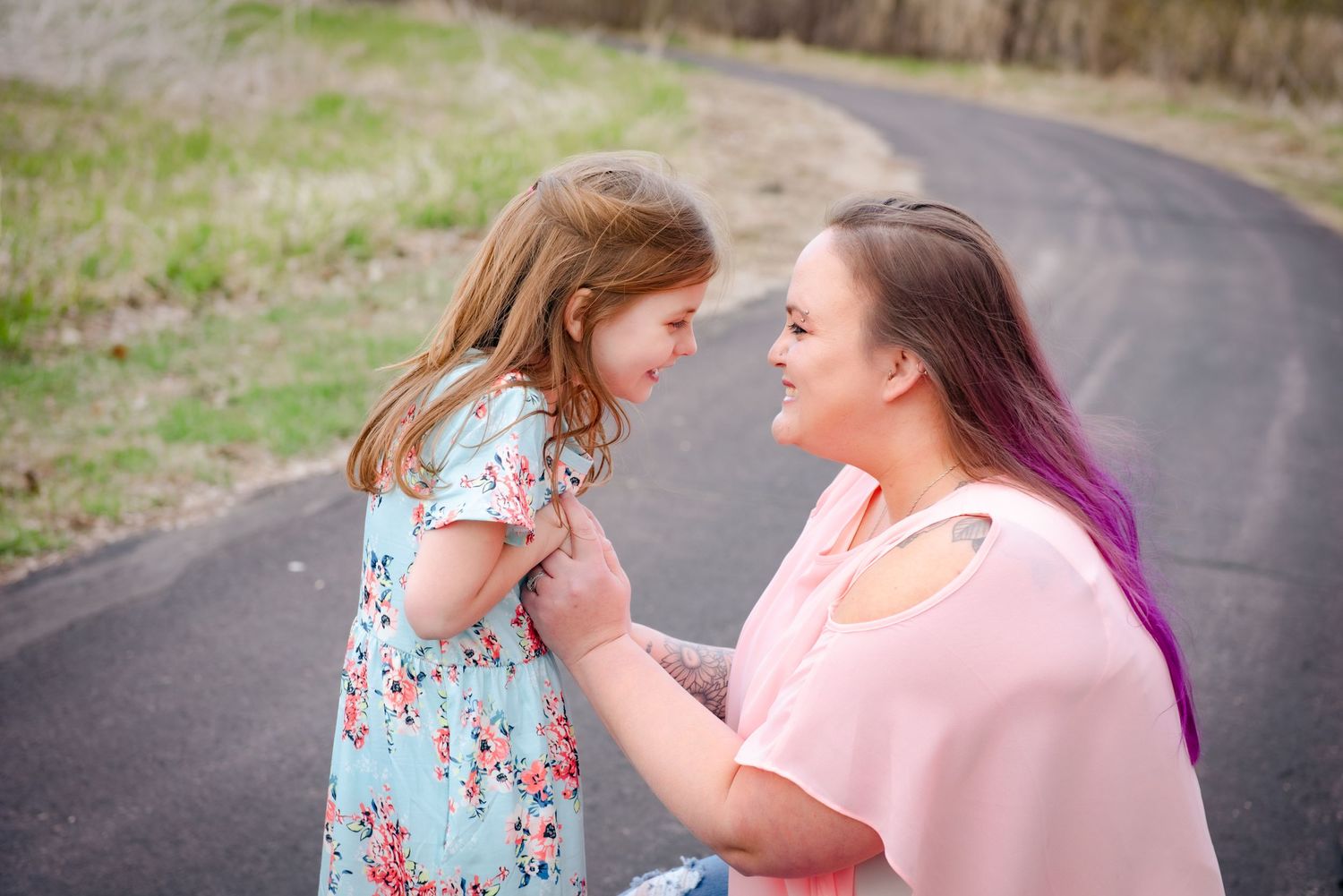 An intimate moment captured between parent and child on a winding path outdoors.
