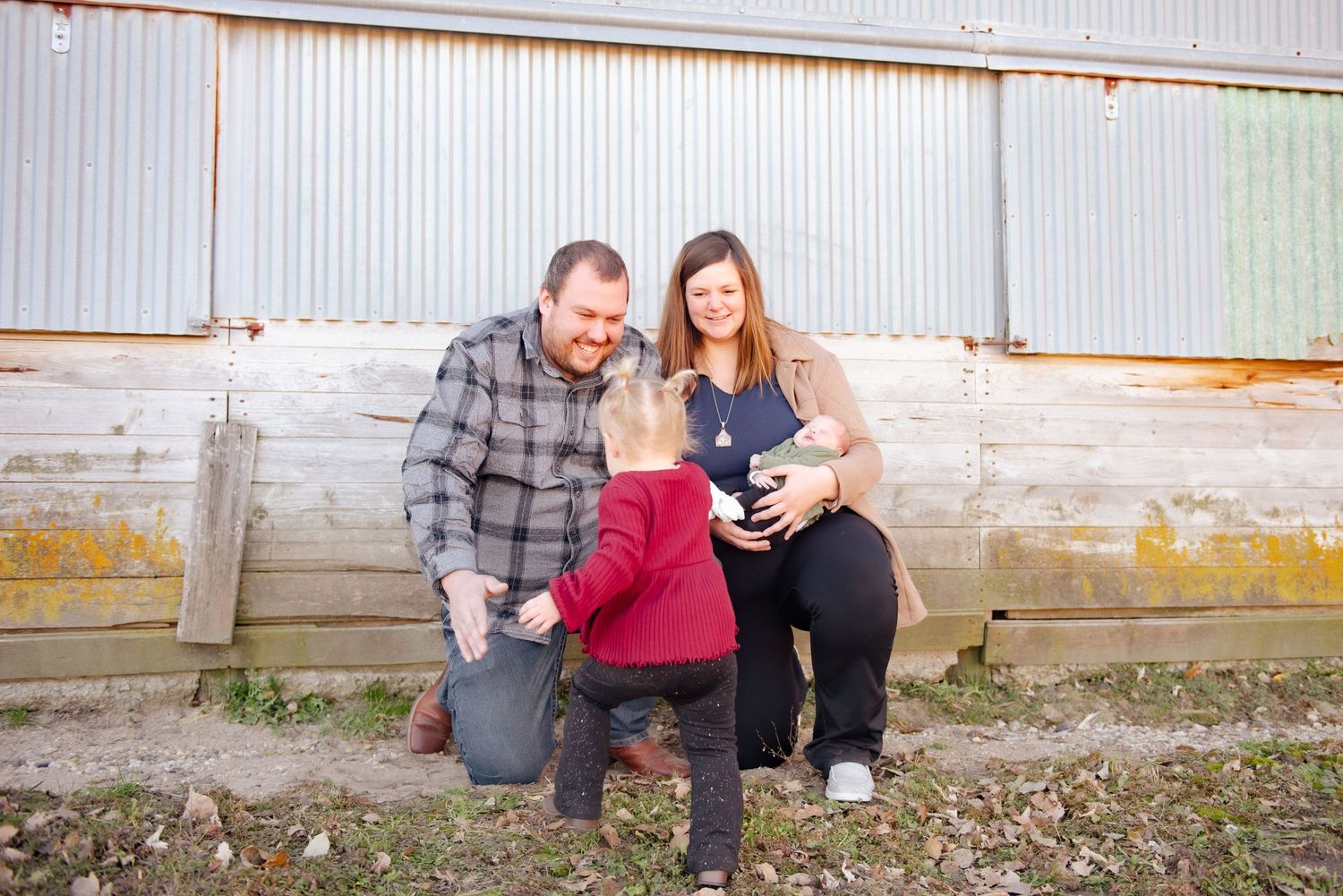 Family kneeling together for casual outdoor portrait.