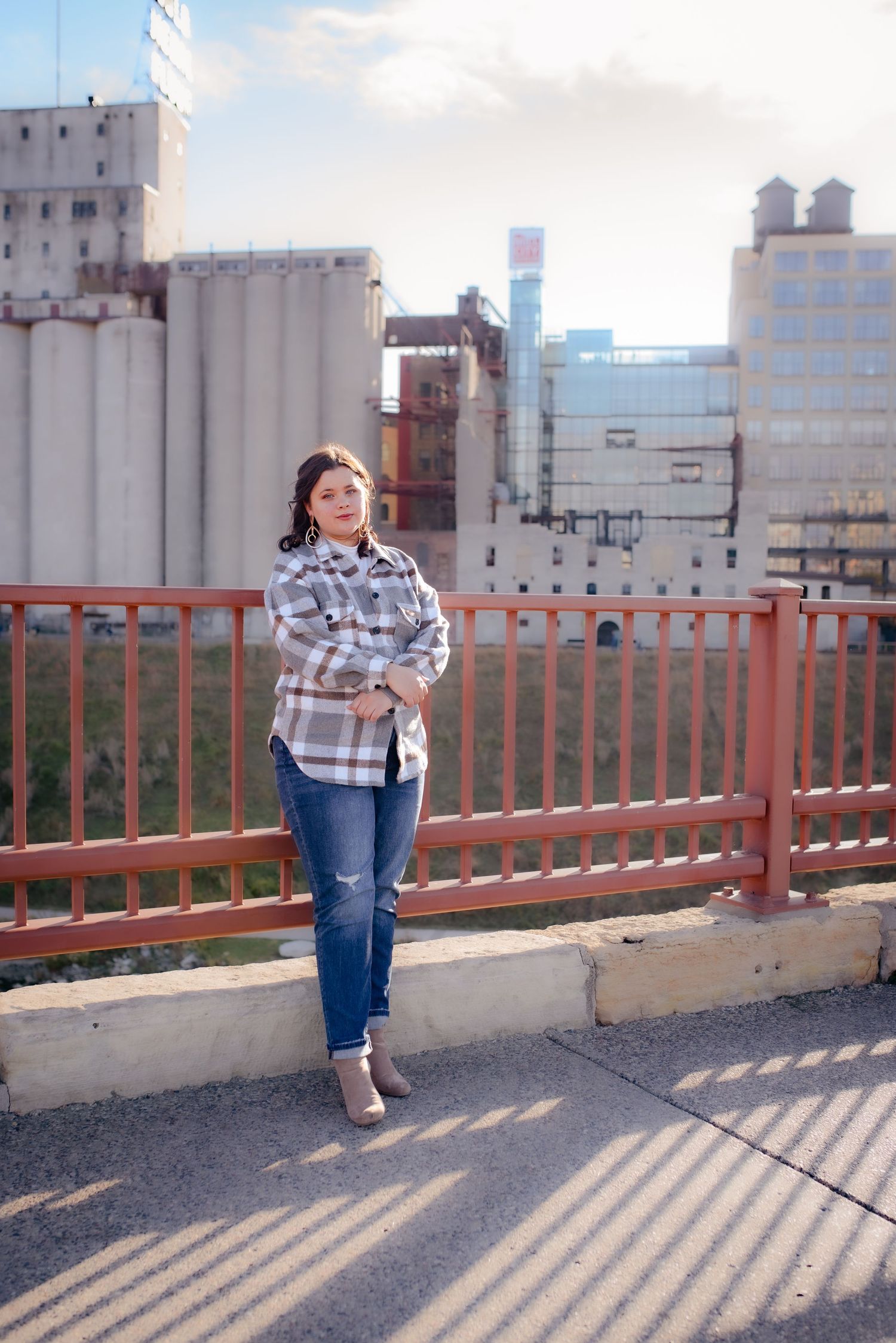 Urban portrait on bridge with industrial buildings and silos in background.