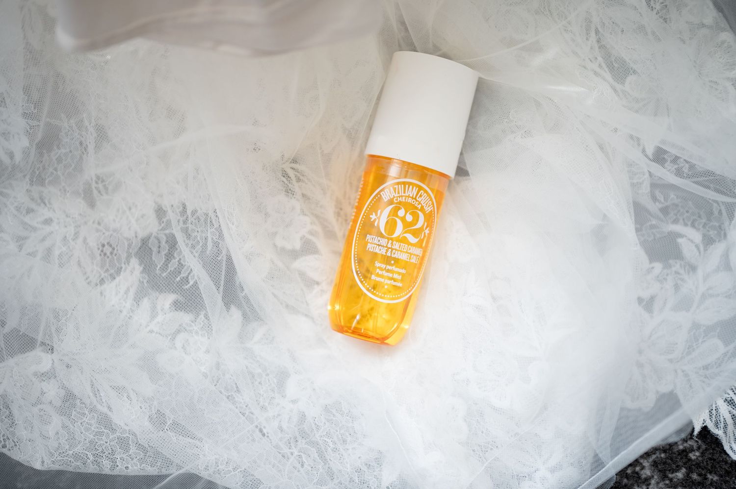 Orange sunscreen bottle nestled in white tulle fabric.