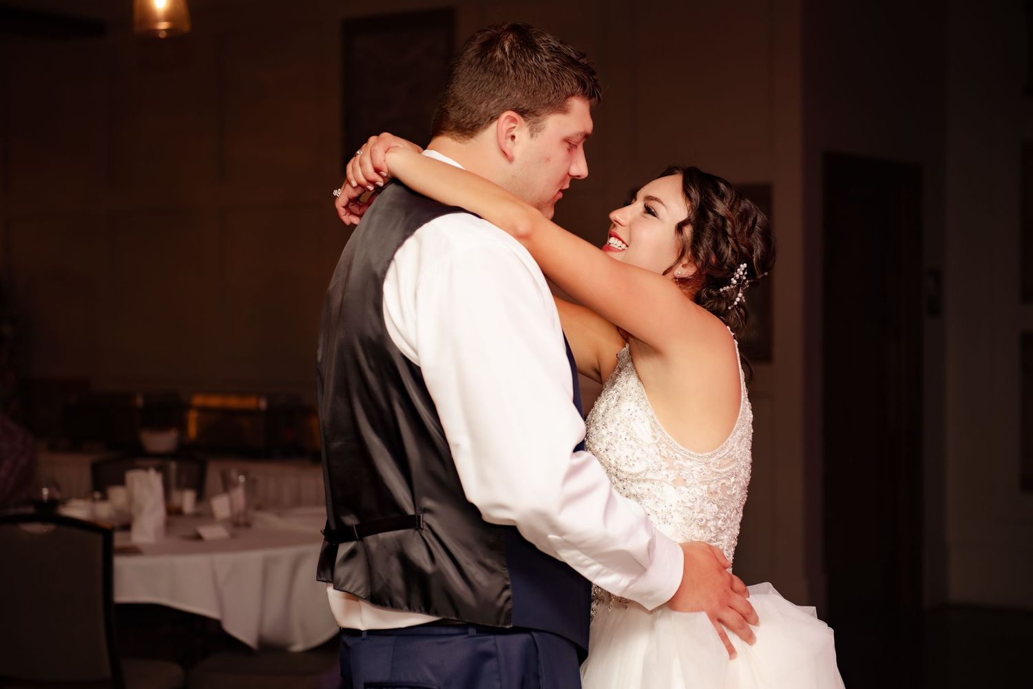 An intimate dance moment captured at a wedding reception with warm lighting.