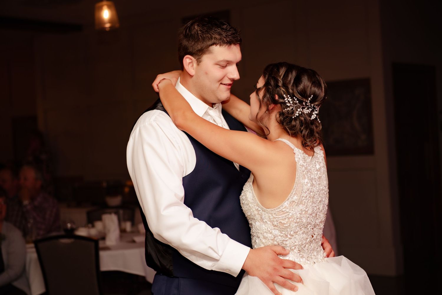 A tender dance moment between newlyweds at their wedding reception.