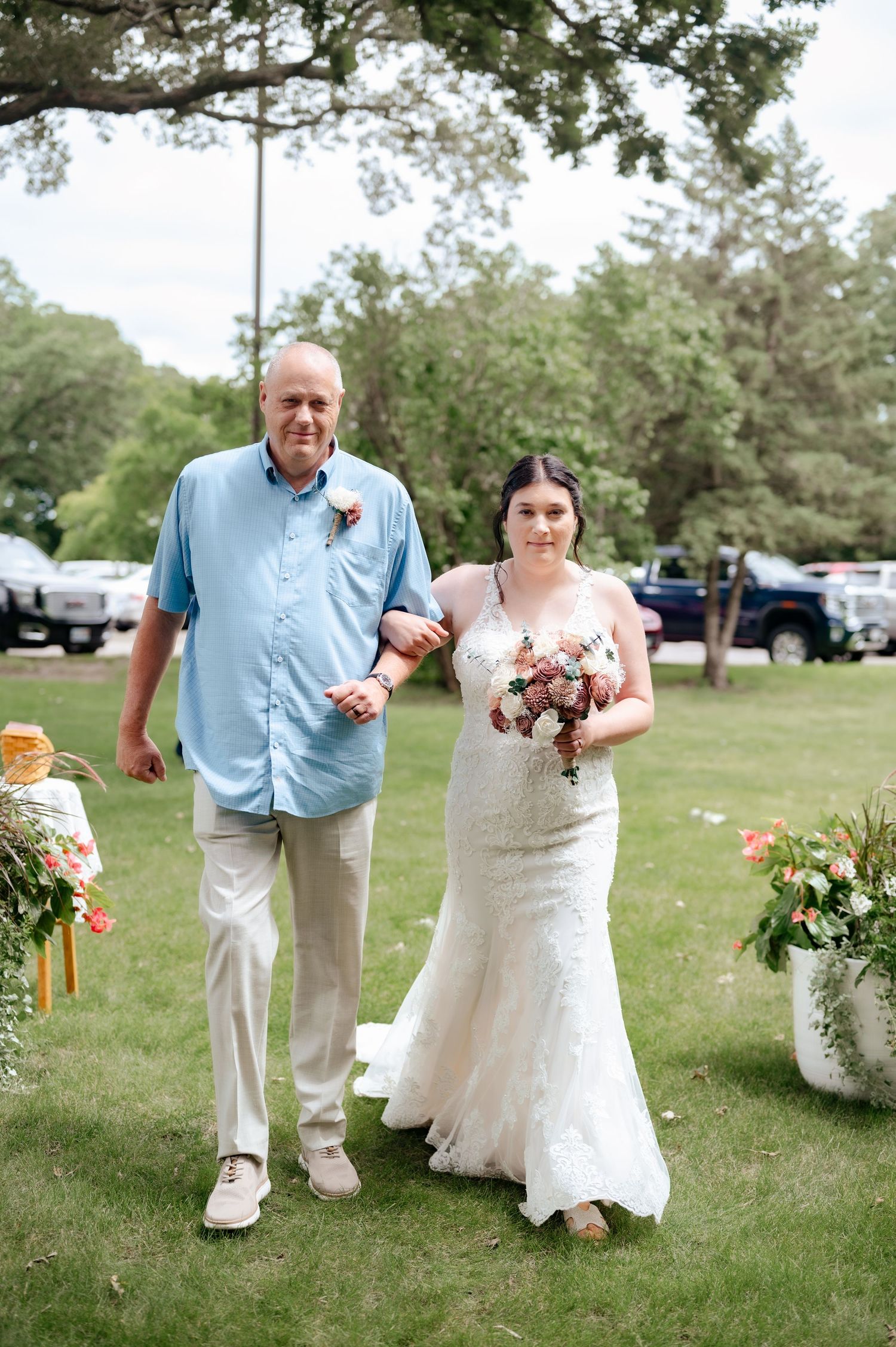 Walking down the aisle at an outdoor wedding ceremony with beautiful floral arrangements.