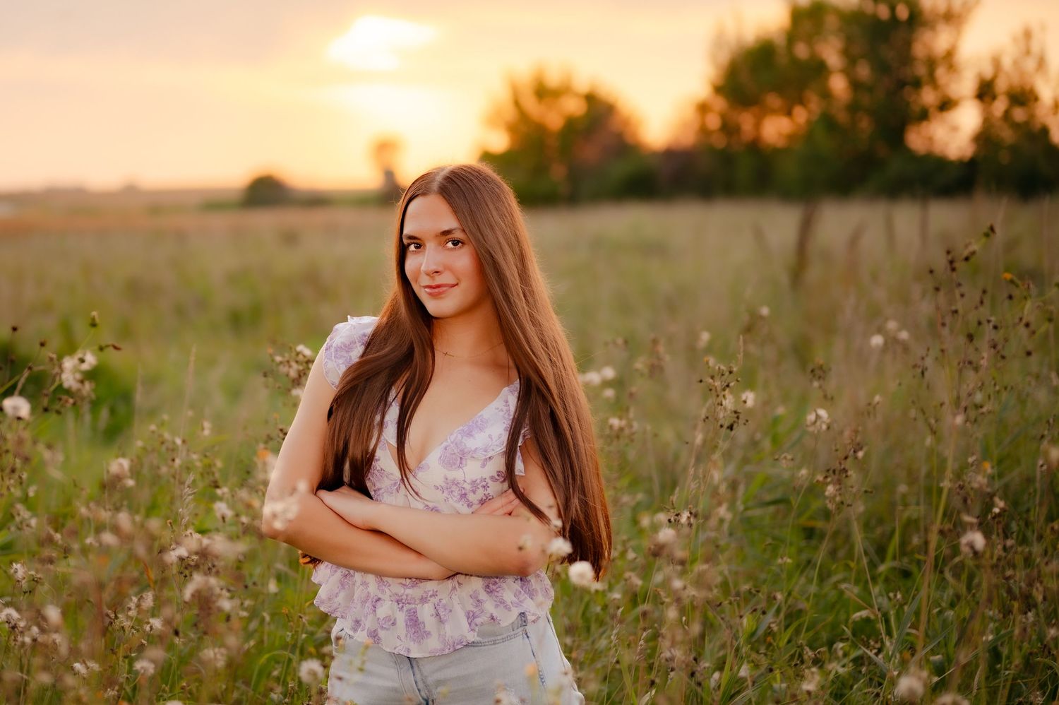 A romantic summer photoshoot in a field of tall grass and wildflowers during golden hour.
