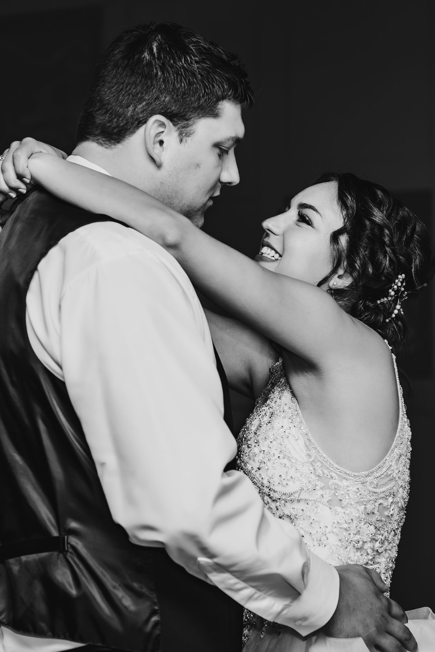 A black and white candid photo captures an intimate dance moment between a couple.