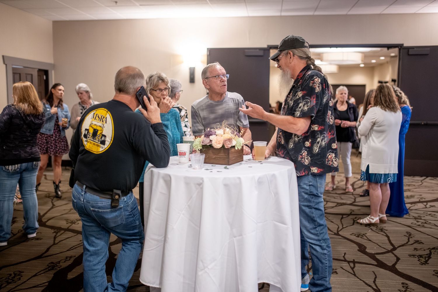 Wedding guests gather around a cocktail table during the reception celebration.