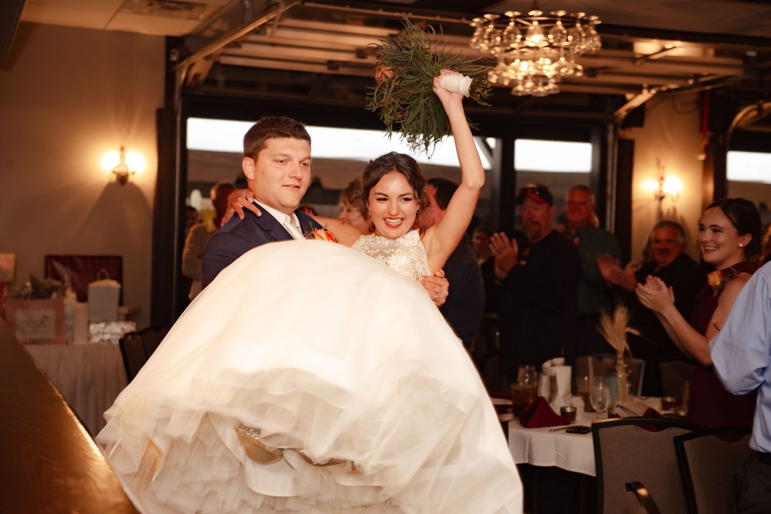 A celebratory moment during a wedding reception with a playful entrance.