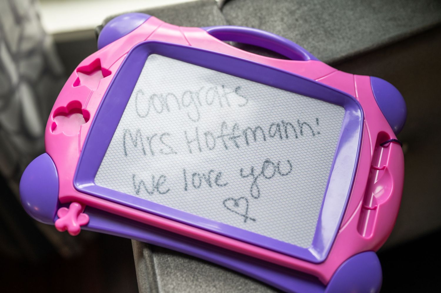 Purple children's drawing tablet with handwritten message displayed.
