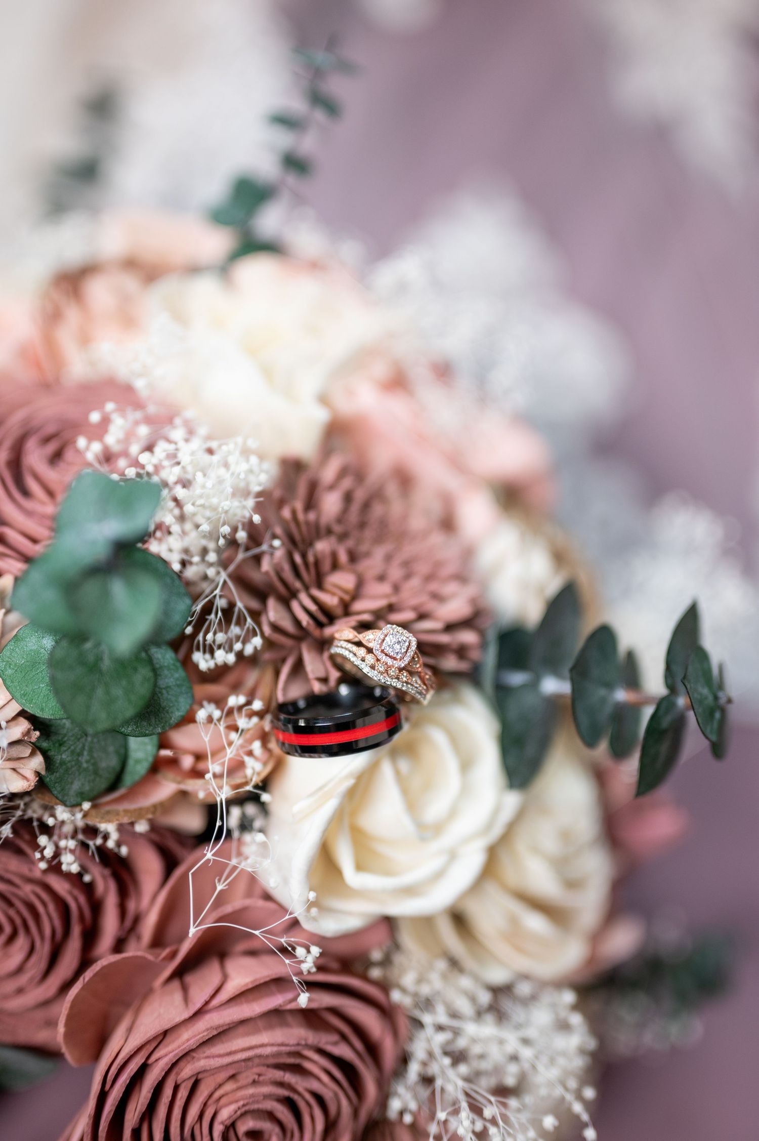 Close-up of a romantic wedding bouquet with dusty rose flowers, white roses, and eucalyptus.
