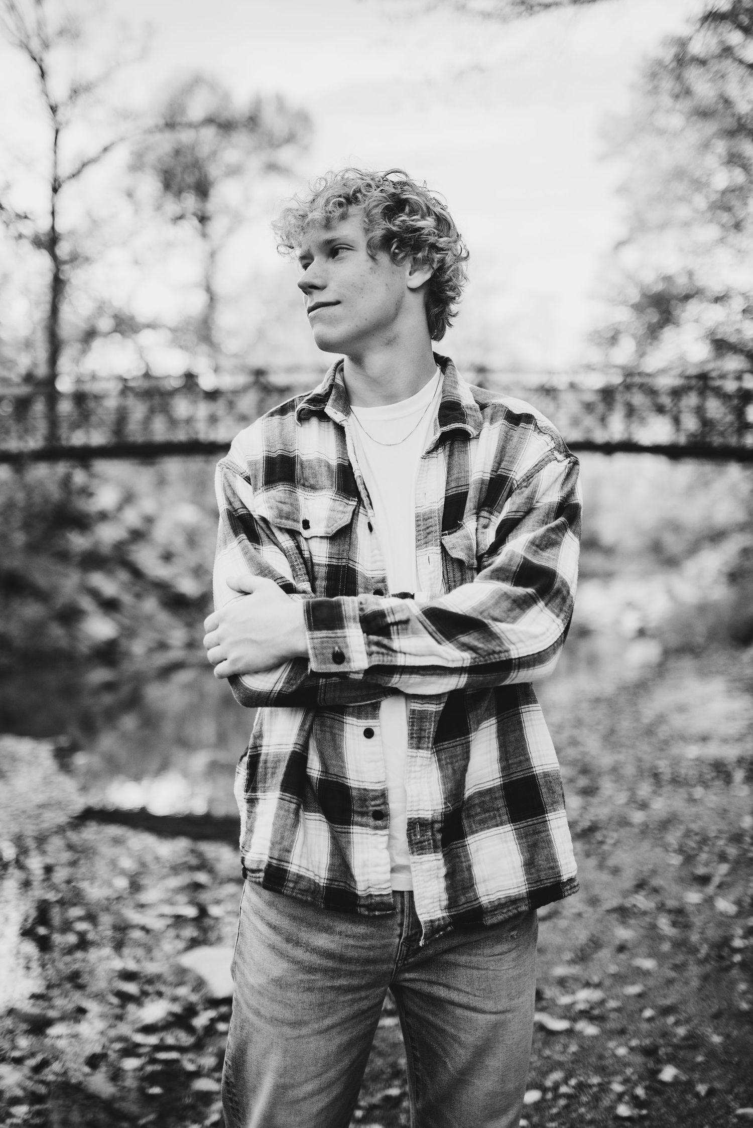 Black and white portrait of someone wearing a plaid flannel shirt in an outdoor setting.