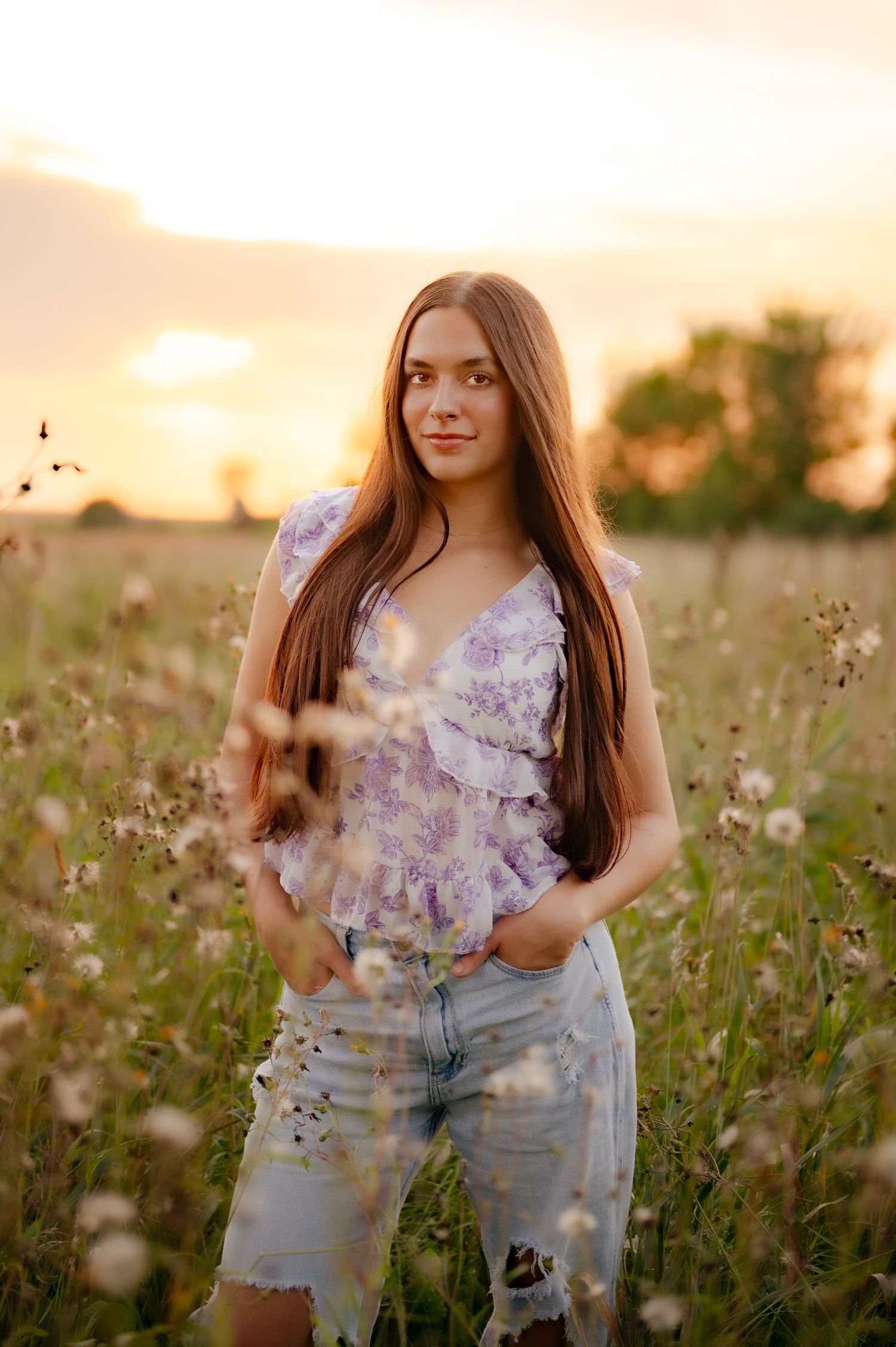 Summer portrait session in blooming wildflower field during sunset.