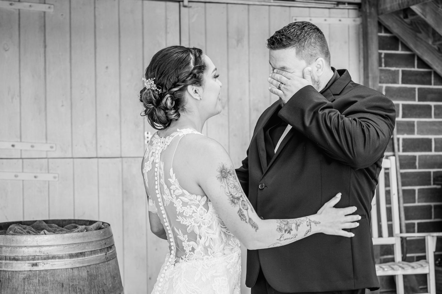 A tender black and white moment between a couple on their wedding day showing emotion and lace dress details.