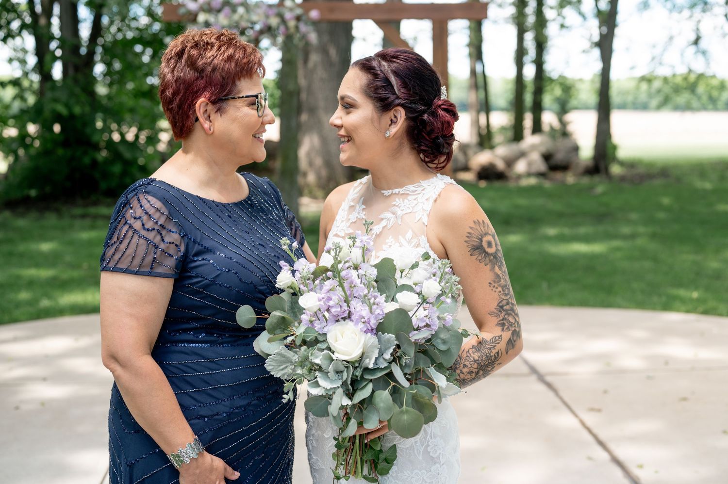 Intimate wedding moment captured between two people with a beautiful floral bouquet.
