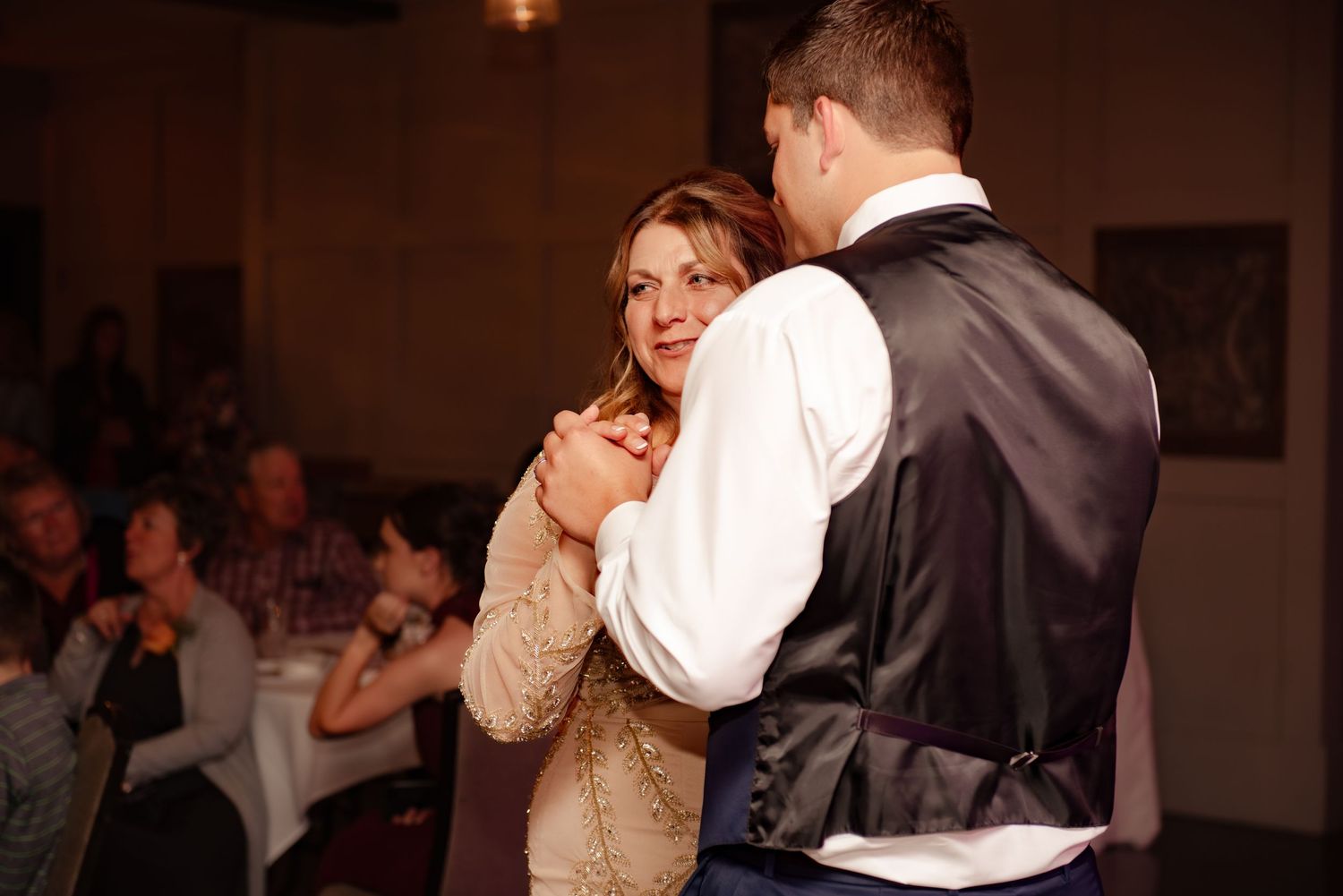Couple sharing romantic dance at wedding reception in formal attire.