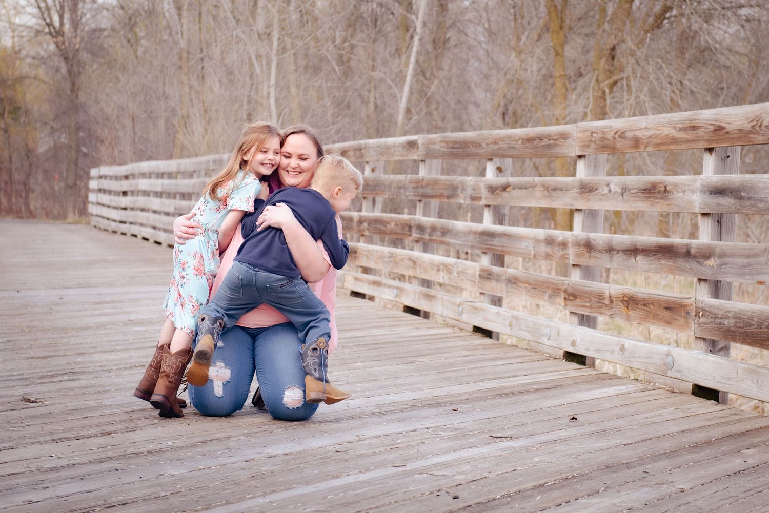 Group sharing embrace and smiles on wooden bridge.