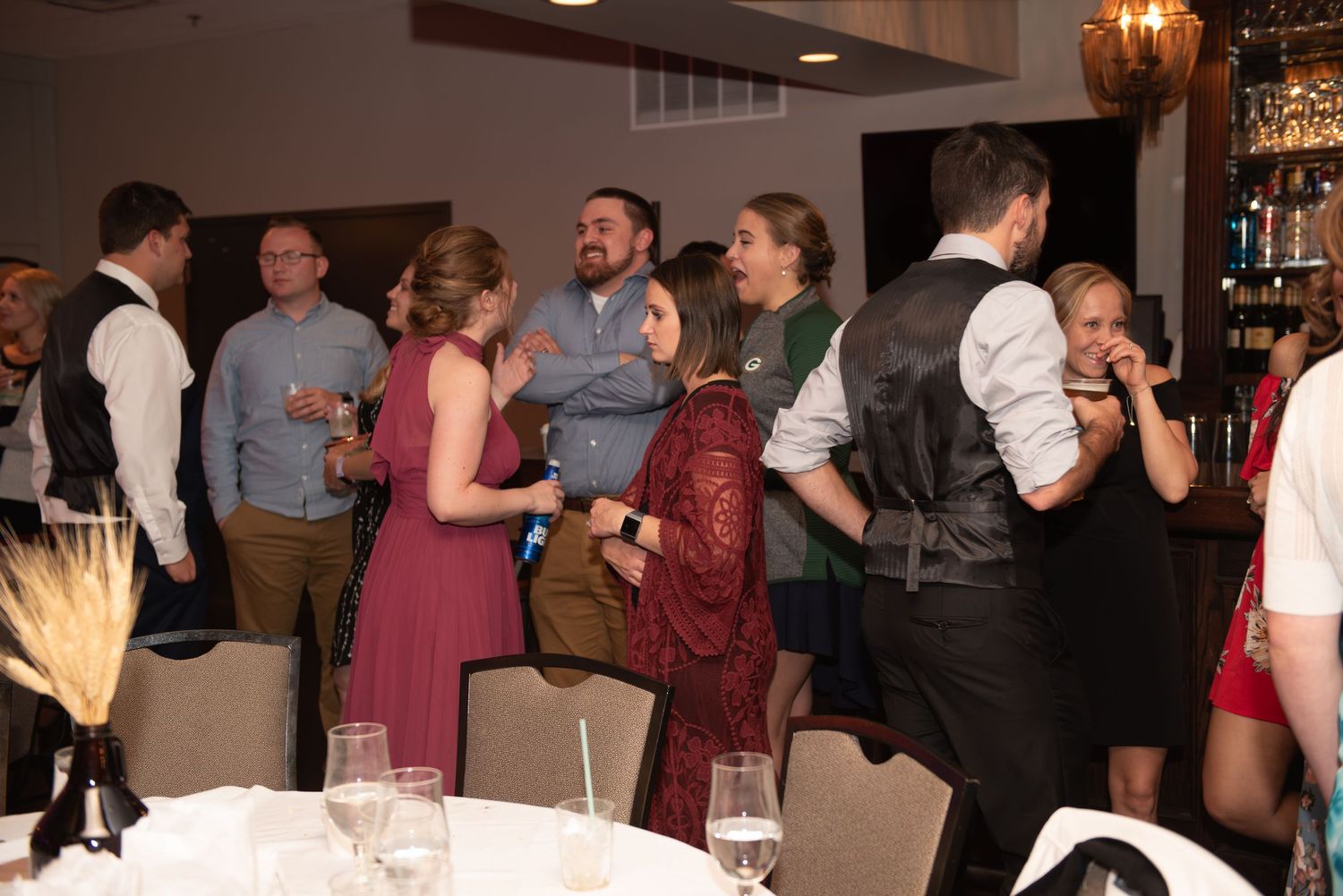 Wedding guests mingling and socializing at reception with drinks.