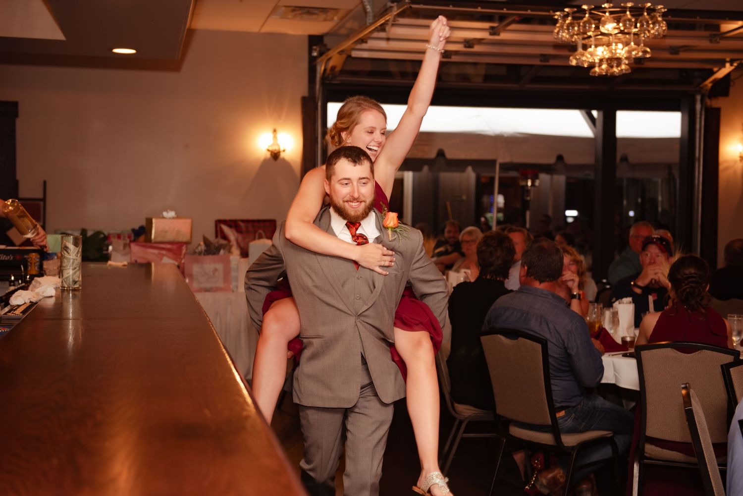 Energetic entrance at a wedding reception with guests looking on.