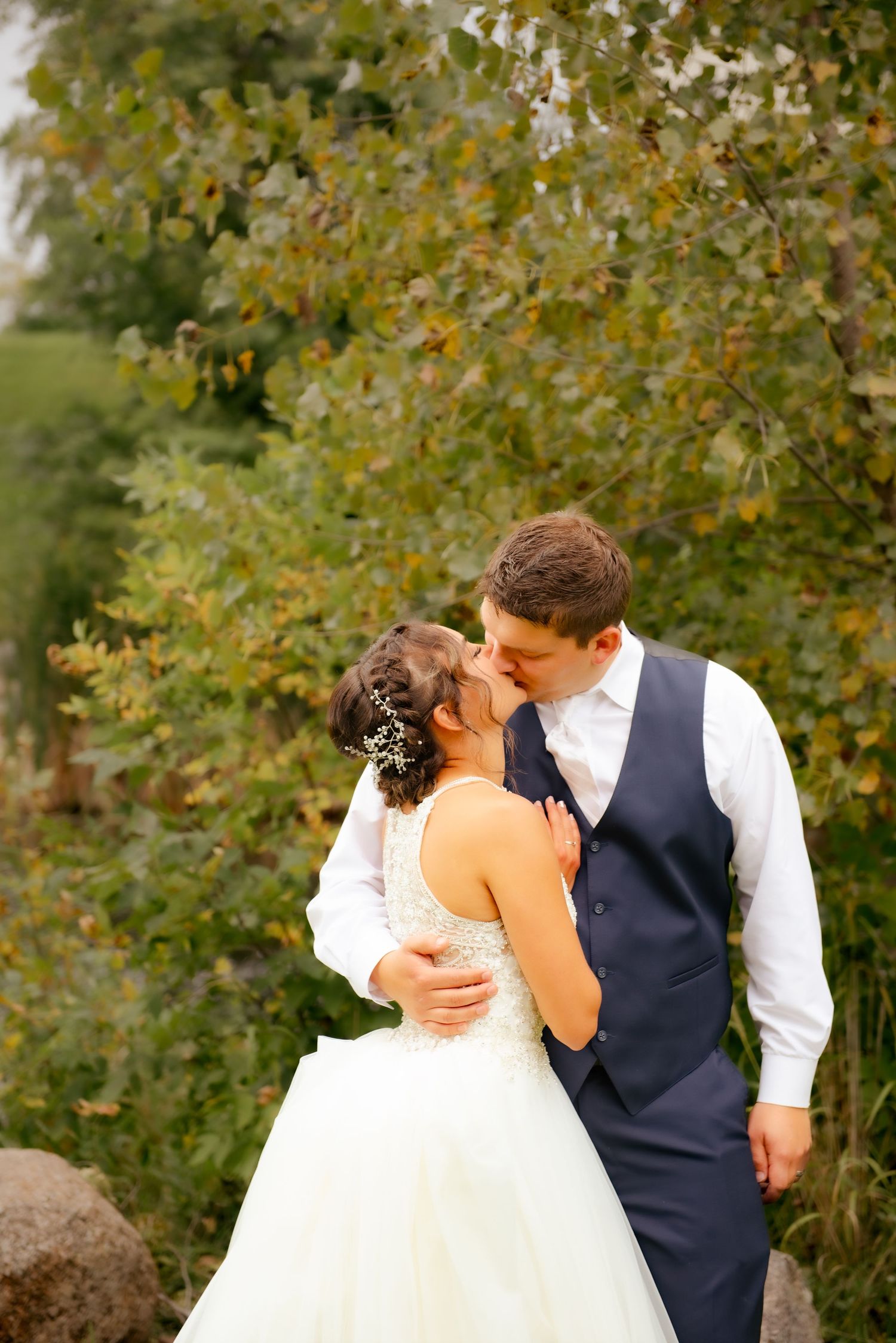 An intimate wedding portrait captured among fall foliage and natural scenery.