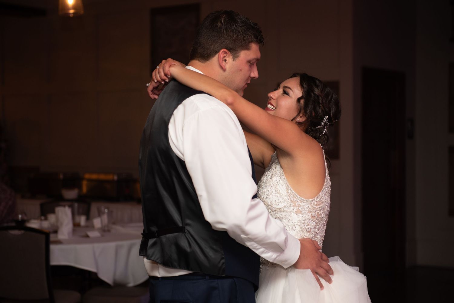 A romantic dance embrace between newlyweds at their wedding reception.