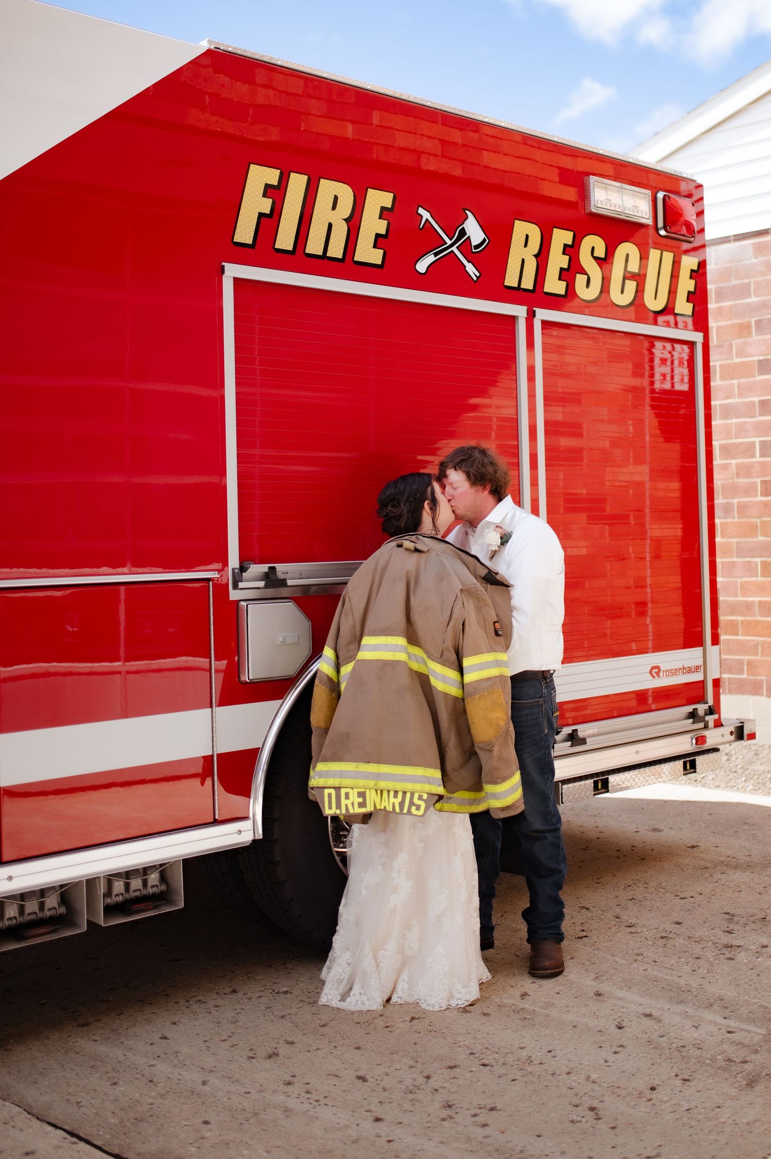 Romantic moment between newlyweds in front of a red fire rescue truck.