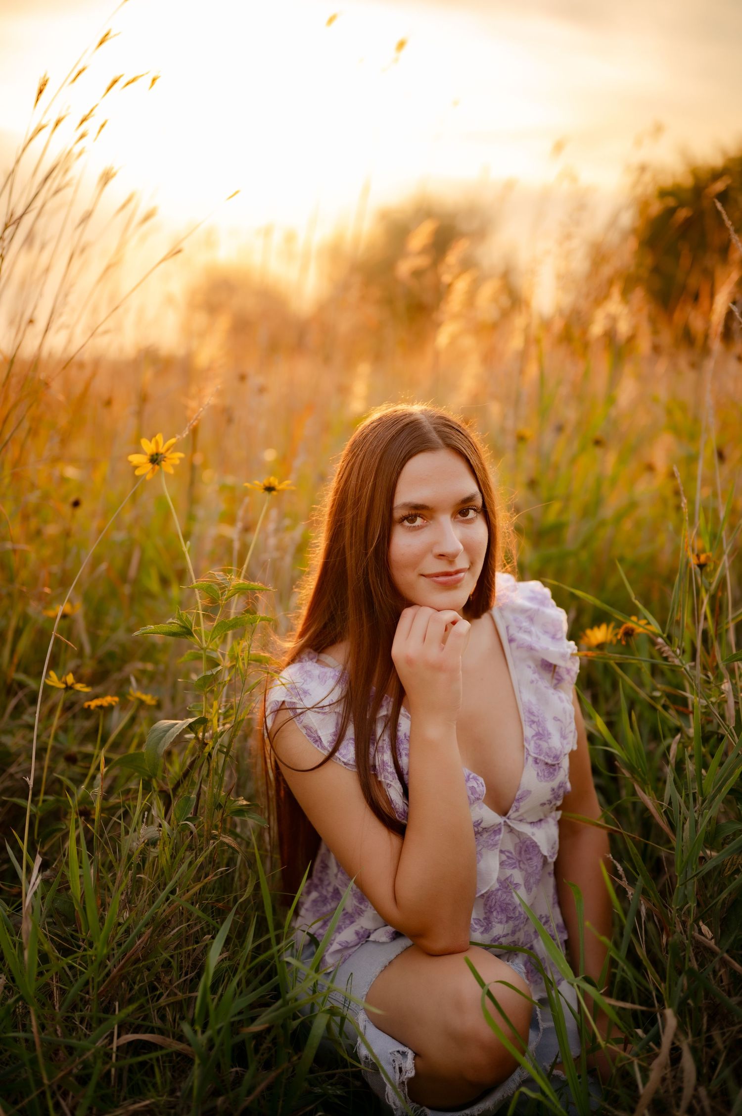 A dreamy outdoor portrait session in a golden wildflower meadow at sunset with warm glowing light.