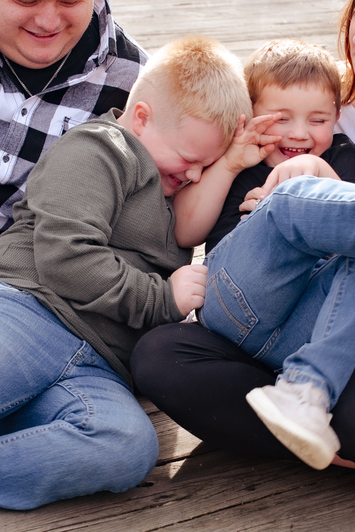 Candid moment of playful laughter and fun on wooden deck.