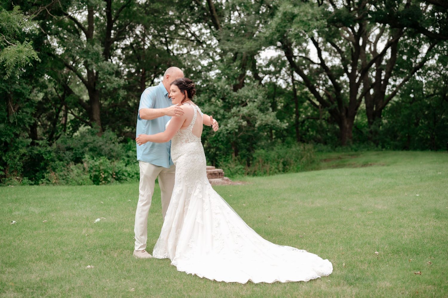 Couple sharing a romantic moment outdoors in a lush garden setting during their wedding day celebration.